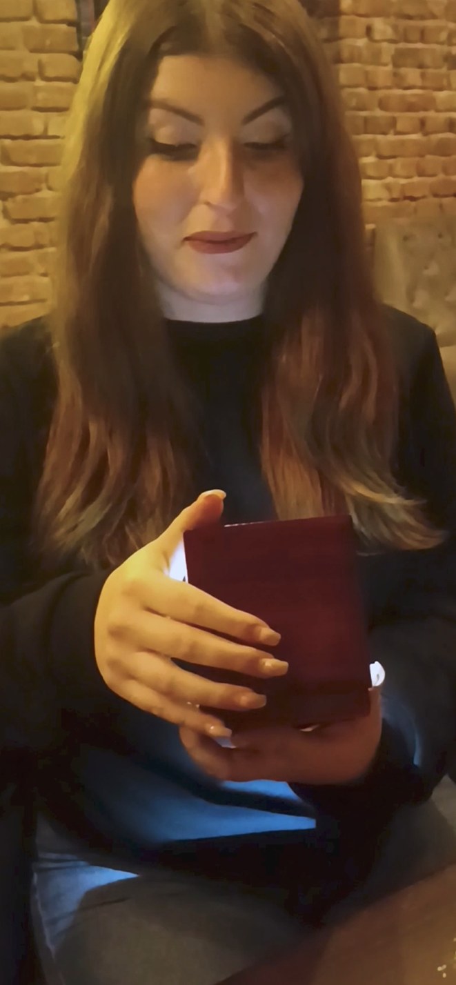 Woman smiling as she opens a JeweLayer necklace gift box