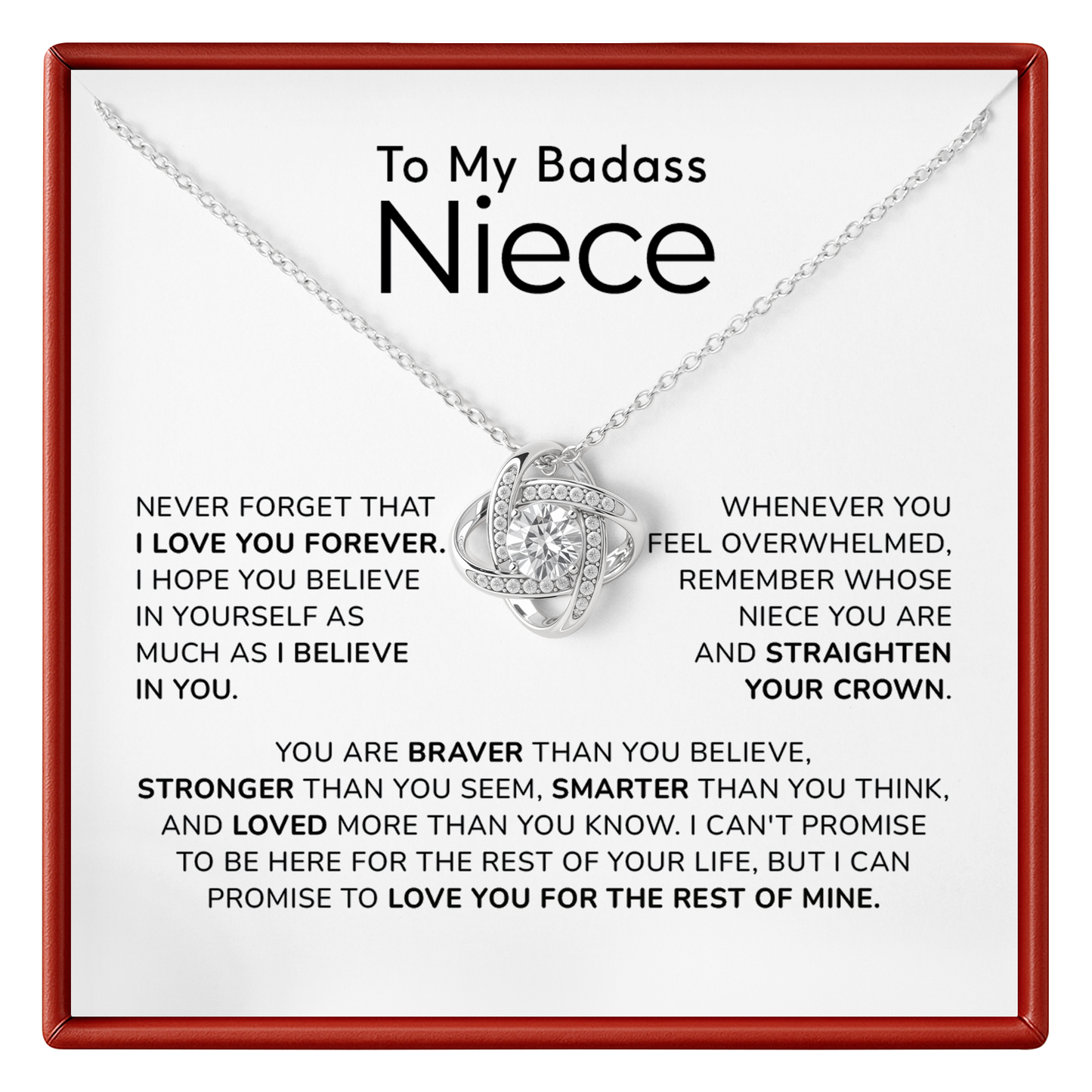 A silver necklace with a heart-shaped pendant set with small clear stones, presented on a white card with a red border. The card is addressed 'To My Badass Niece' and features a sentimental message printed in black text.