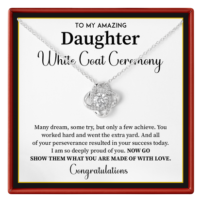 A silver necklace with a heart-shaped pendant set with small clear stones, presented on a white card with a red frame. The card reads 'TO MY AMAZING Daughter White Coat Ceremony' with a congratulatory message.