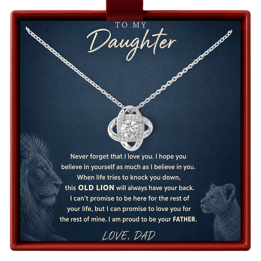 A silver necklace with a circular pendant set with small clear stones, presented inside a red gift box. The necklace is displayed on a dark blue card with sentimental text addressed to a daughter, featuring silhouettes of a lion.