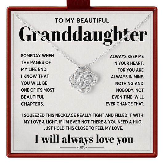 A silver necklace with a heart-shaped pendant set with small clear stones, displayed on a printed gift card addressed to a granddaughter with sentimental text and a red border.