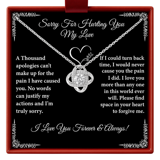 Necklace with heart design on a black background with apology message
