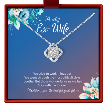 Necklace with a heart-shaped pendant in a decorative box with floral elements and text.
