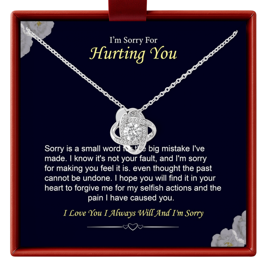 Necklace with a heart-shaped pendant in a box with an apology message.