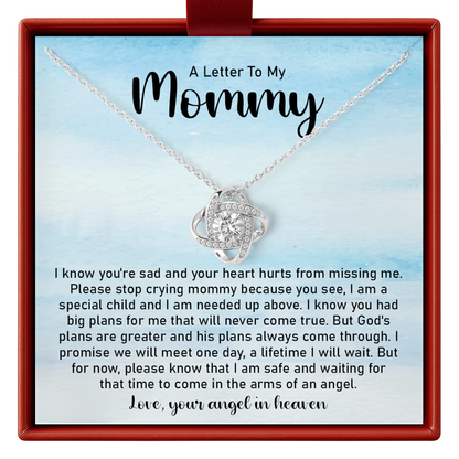 Necklace with heart pendant in a box with a letter to 'Mommy' on a blue background