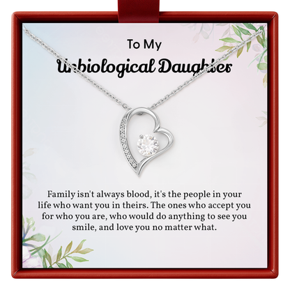 Heart-shaped necklace on a card with text for 'Unbiological Daughter' in a decorative box.