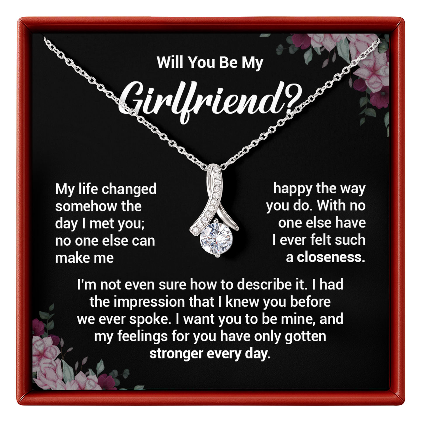 Necklace with a diamond pendant in a box with romantic message, surrounded by floral decorations.